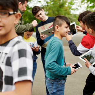 This image shows children using iPads to talk